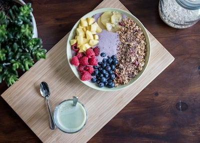 A large bowel of fruit and nuts on a wooden cutting board - 5 ways to maximize your mental health.
