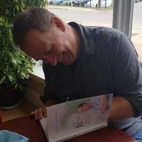 Jonathan signing a book at his first book signing