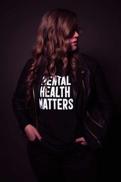 Brown-haired woman wearing a shit with mental health matters written on it - Why Mental Health Matters