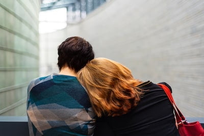 A redheaded woman resting her head on the shoulder of a short-haired, brunette man back to. 10 signs you’re a highly sensitive person.